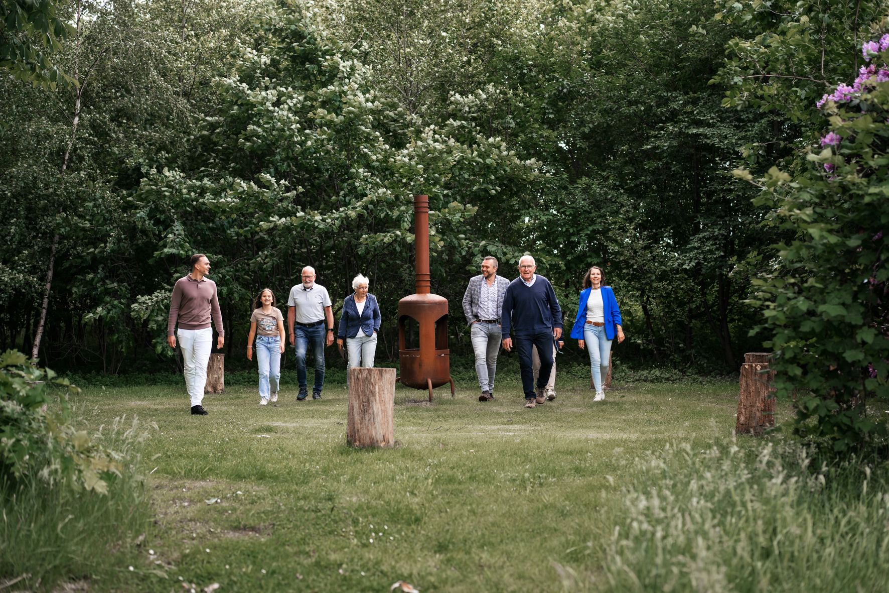 Een groep mensen van verschillende leeftijden wandelt samen over een grasveld